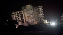 The damaged remaining structure at the Champlain Towers South condo building collapses in a controlled demolition, Sunday, July 4, 2021, in Surfside, Fla. The decision to demolish the Surfside building came after concerns mounted that the damaged structure was at risk of falling, endangering the crews below and preventing them from operating in some areas.(AP Photo/Lynne Sladky)
