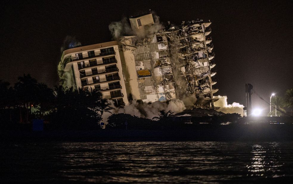 A controlled explosion brings down the unstable remains of the building on July 4.