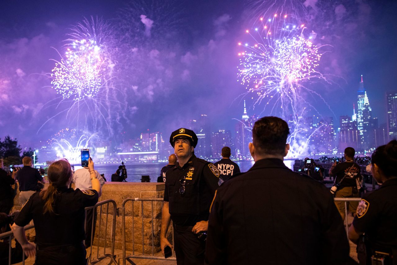 NYPD officers watch fireworks light up the night sky as seen from Hunter's Park South on July 4, in New York. 