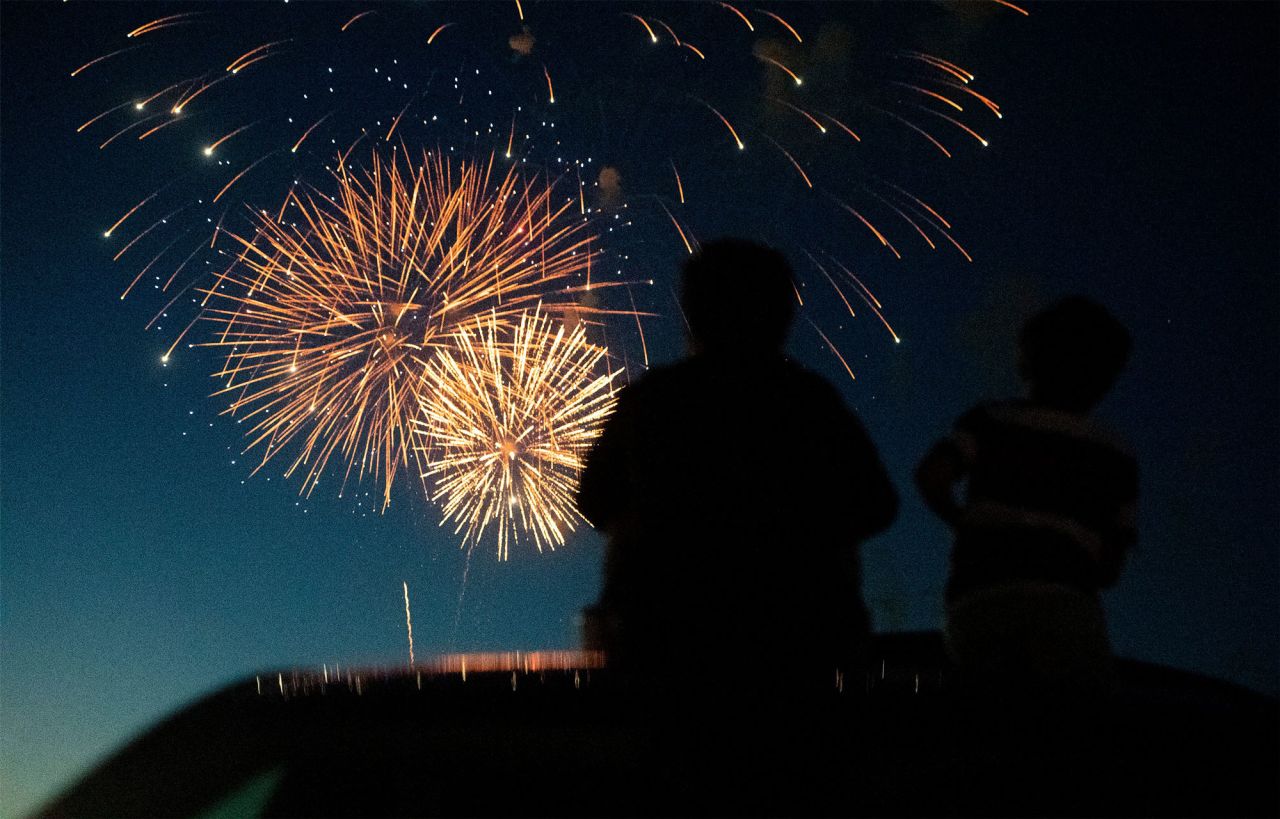 People sit on their car during the fireworks show at The Ranch events complex in Loveland, Colo. on Sunday, July 4.