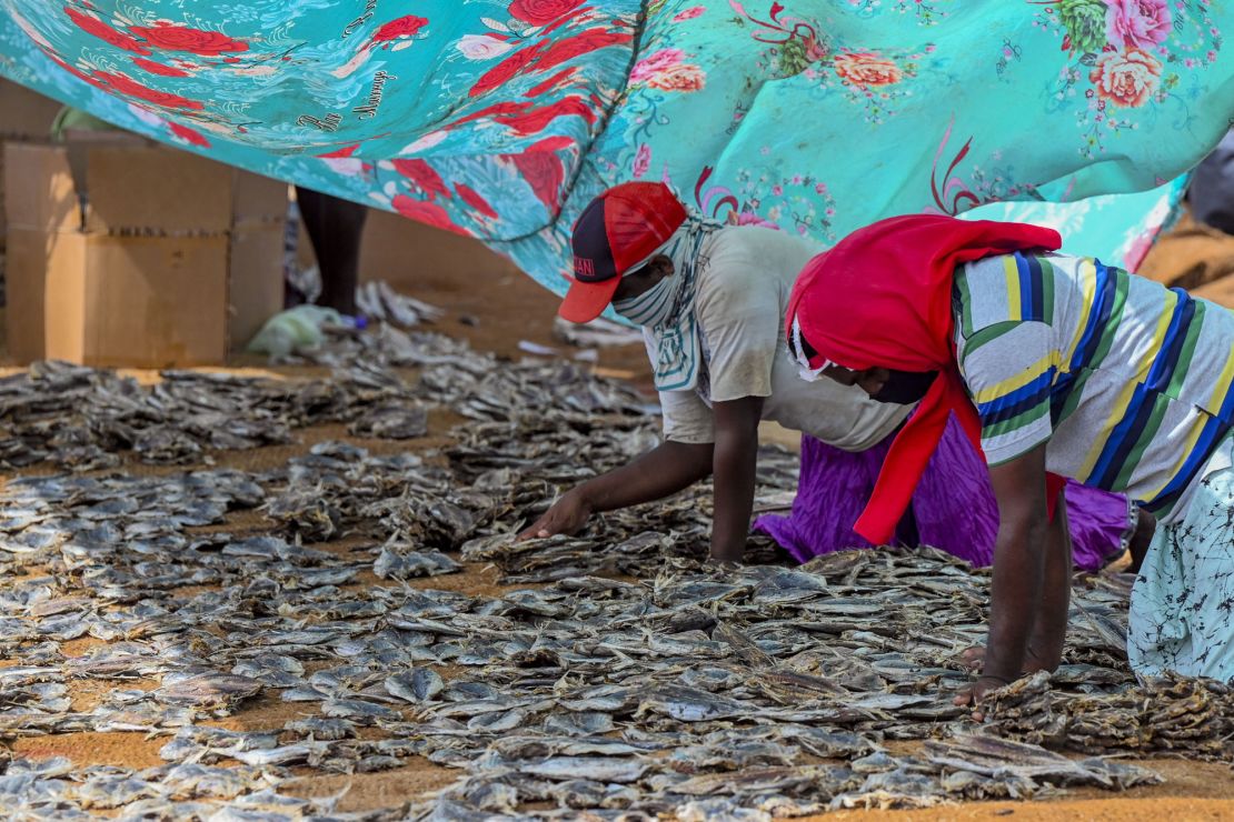 Workers process salted fish in Negombo, where plastic raw materials and other debris washed ashore.