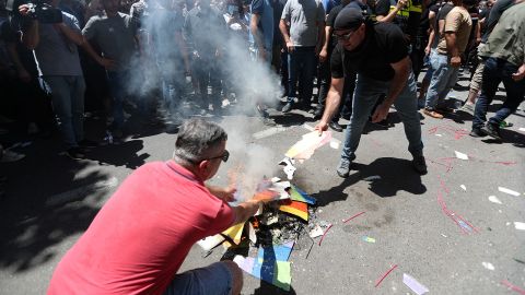 Anti-LGBT protesters burn a rainbow banner as they take part in a rally ahead of the march on Monday.