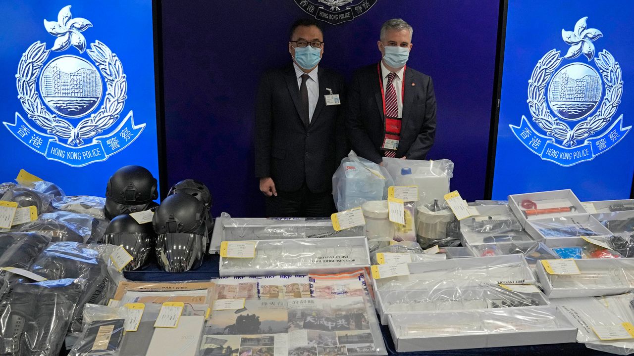 Senior Superintendent Steve Li , left, of Hong Kong Police National Security Department, and senior bomb disposal officer Alick McWhirter, right, of Explosive Ordnance Disposal Bureau, pose with the confiscated evidence during a news conference Tuesday.
