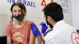 An Israeli girl receives a dose of the Pfizer/BioNTech Covid-19 vaccine from the Magen David Adom during a campaign by the Tel Aviv-Yafo Municipality to encourage the vaccination of teenagers, on July 5, 2021, in Tel Aviv. - Israel is now urging more 12- to 15-year-olds to be vaccinated, citing new outbreaks attributed to the more infectious Delta variant. (Photo by JACK GUEZ / AFP) (Photo by JACK GUEZ/AFP via Getty Images)