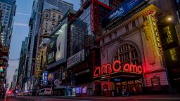 Signage is displayed outside an AMC movie theater at night in the Times Square neighborhood of New York, U.S., on Tuesday, Oct. 15, 2020. AMC Entertainment Holdings Inc. is considering a range of options that include a potential bankruptcy to ease its debt load as the pandemic keeps moviegoers from attending and studios from supplying films. Photographer: Amir Hamja/Bloomberg via Getty Images