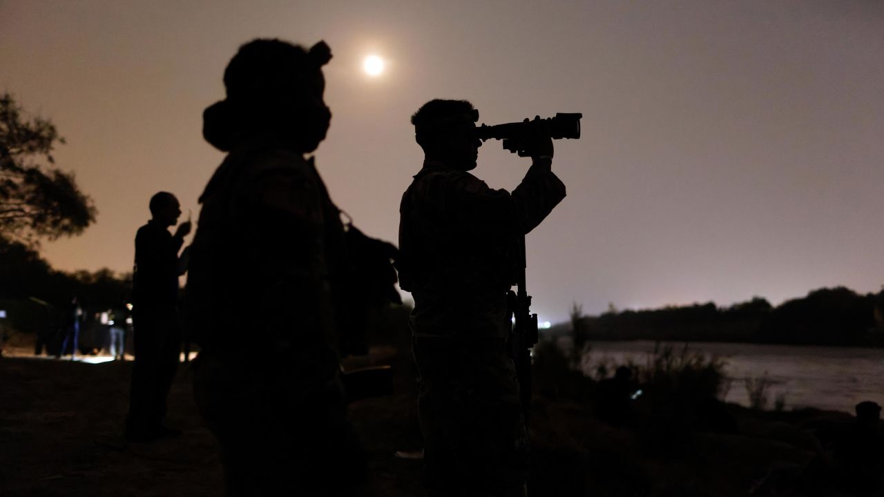 Texas National Guard troops scan the Mexican side of the Rio Grande for immigrants preparing to cross on April 27, 2021 in Roma, Texas.