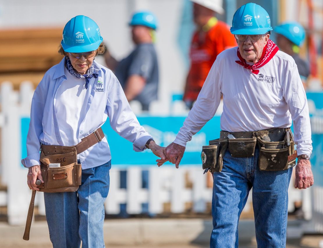 Jimmy and Rosalynn Carter hold hands as they work with other volunteers on site during the first day of the weeklong Jimmy & Rosalynn Carter Work Project, their 35th work project with Habitat for Humanity, in Mishawaka, Indiana in 2018.