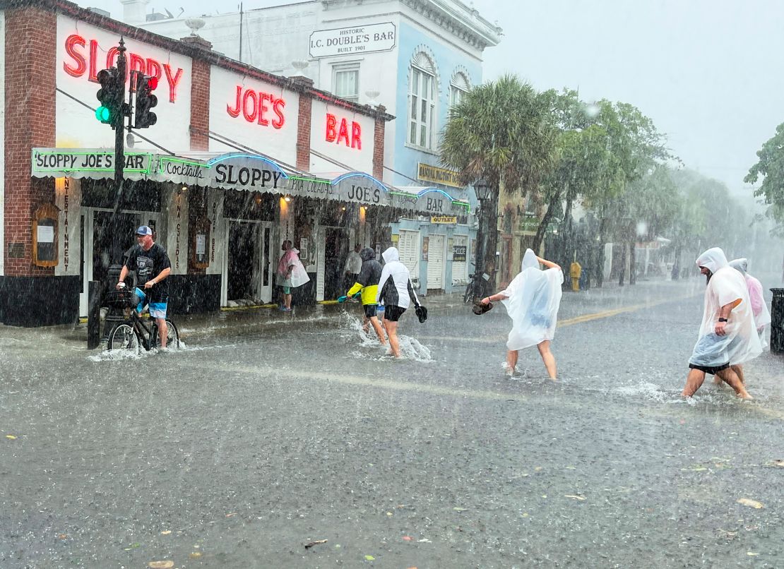 Determined visitors head to Sloppy Joe's bar while crossing a flooded Duval Street in Key West.