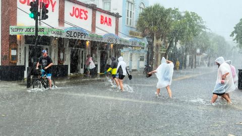 Determined visitors head to Sloppy Joe's bar while crossing a flooded Duval Street in Key West.