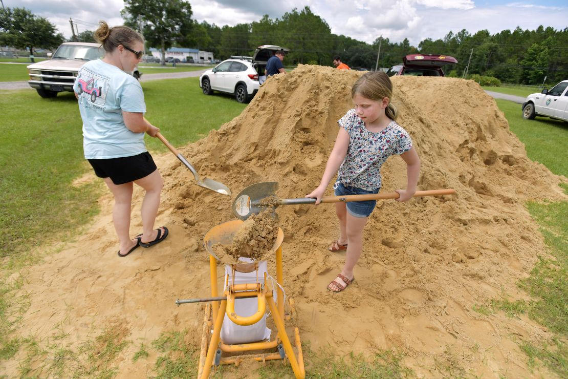 Emma Barlow, 9, works with her mother Brandi Barlow to fill sandbags Tuesday in Middleburg.