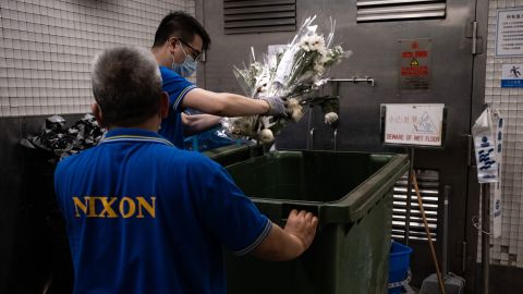 Flowers from the makeshift vigil for the attacker are thrown in the garbage on July 2.