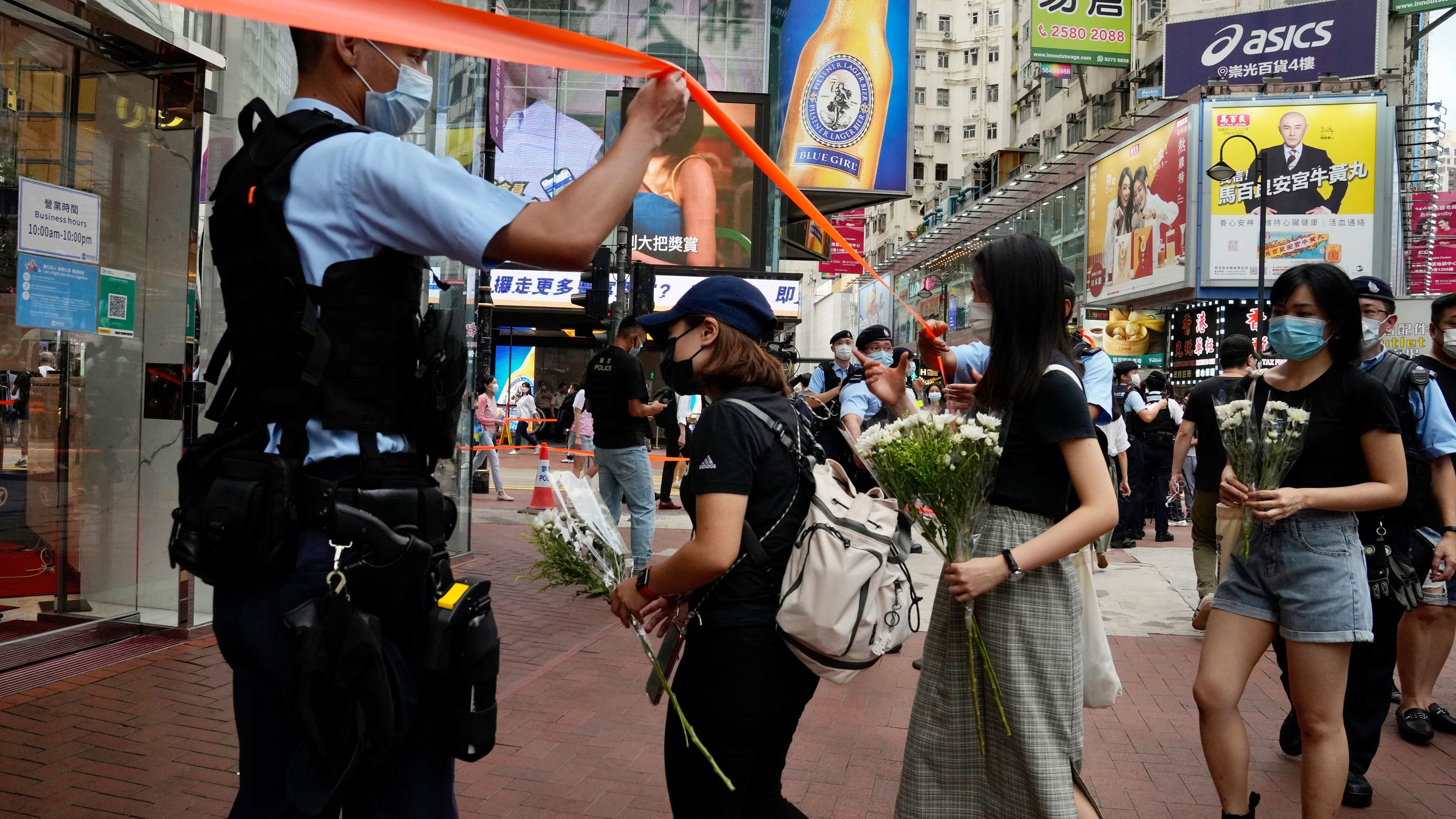 People hold flowers to mourn the death of the assailant.