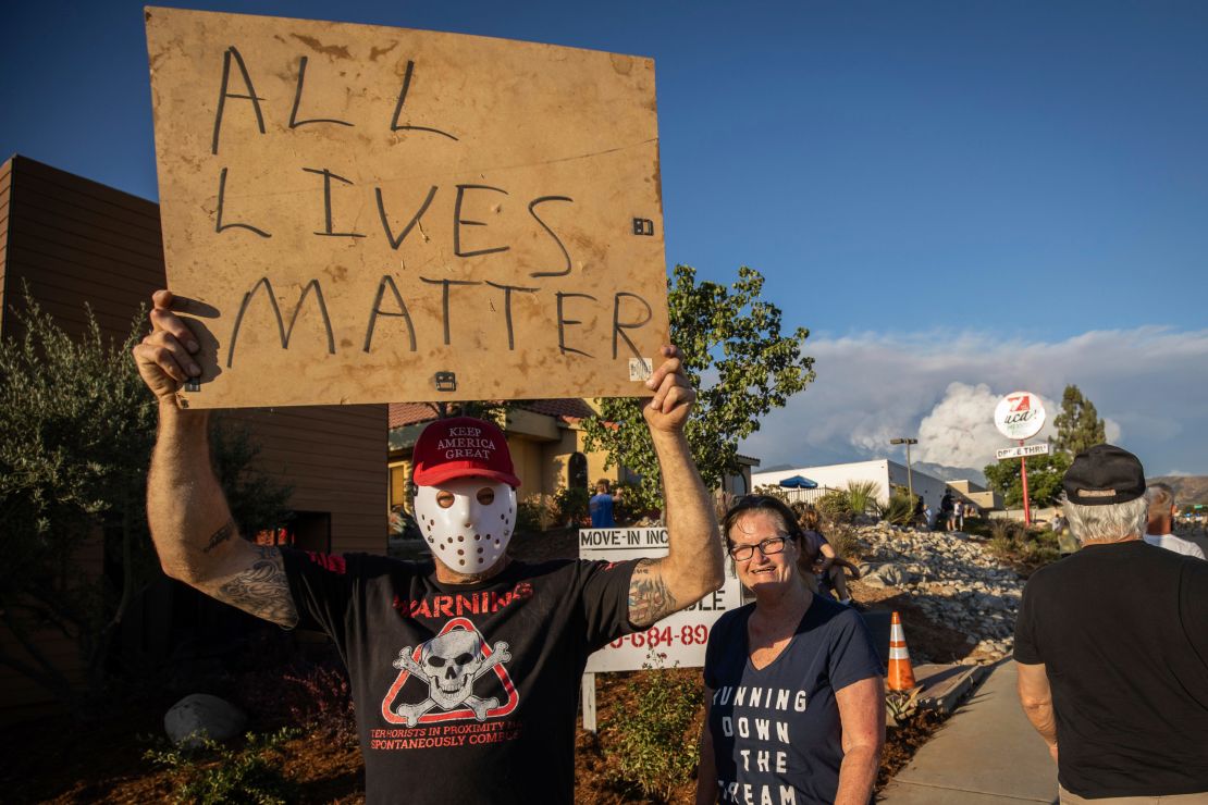 A man holds an "All Lives Matter" sign at a pro-Trump demonstration on August 1, 2020, in Yucaipa, California.