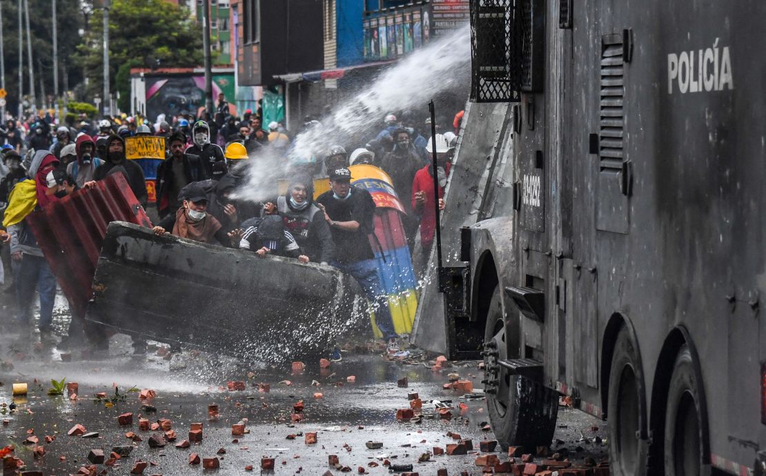 Police officers spray a water cannon at demonstrators during a protest in Bogota, Colombia, on June 9,