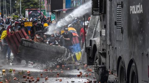 Police officers spray a water cannon at demonstrators during a protest in Bogota, Colombia, on June 9,