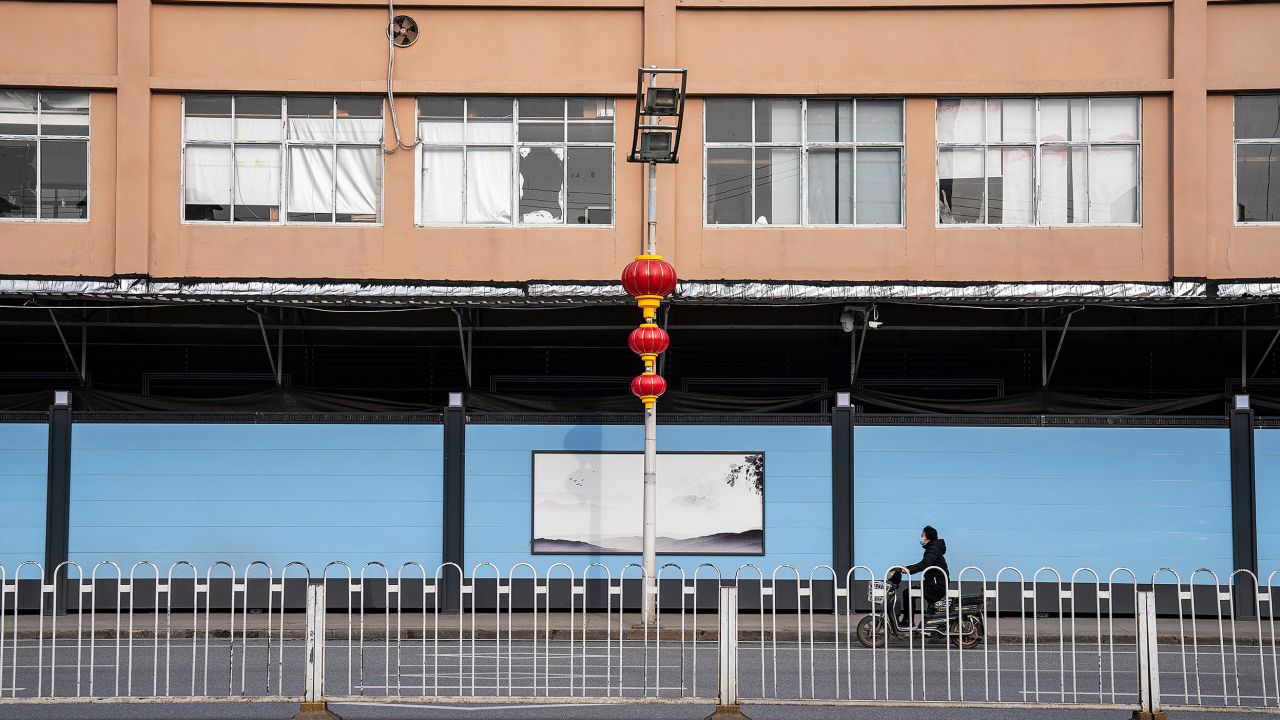 Residents walk in front of a closed of Huanan seafood market on February 9, 2021 in Wuhan, Hubei Province, China.
