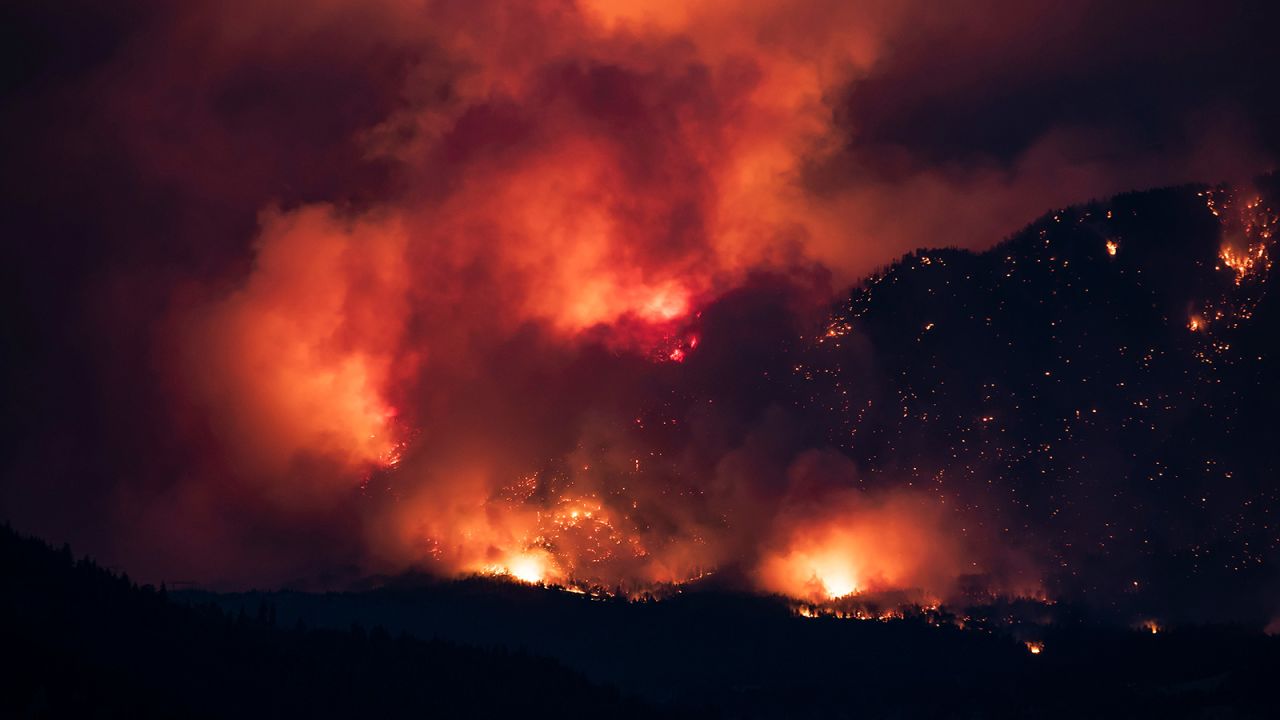 A wildfire burns on the side of a mountain in Lytton, British Columbia, on July 1.