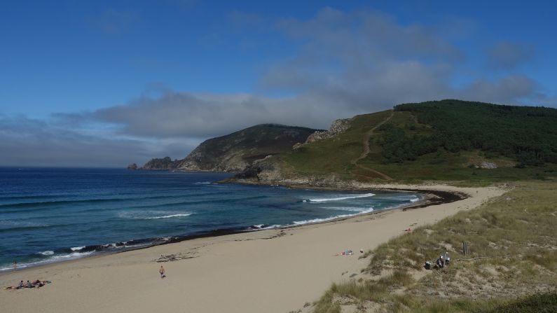 <strong>Beach vacation:</strong> Just outside of Fisterra, a handful of people sun themselves on Playa Langosteira.