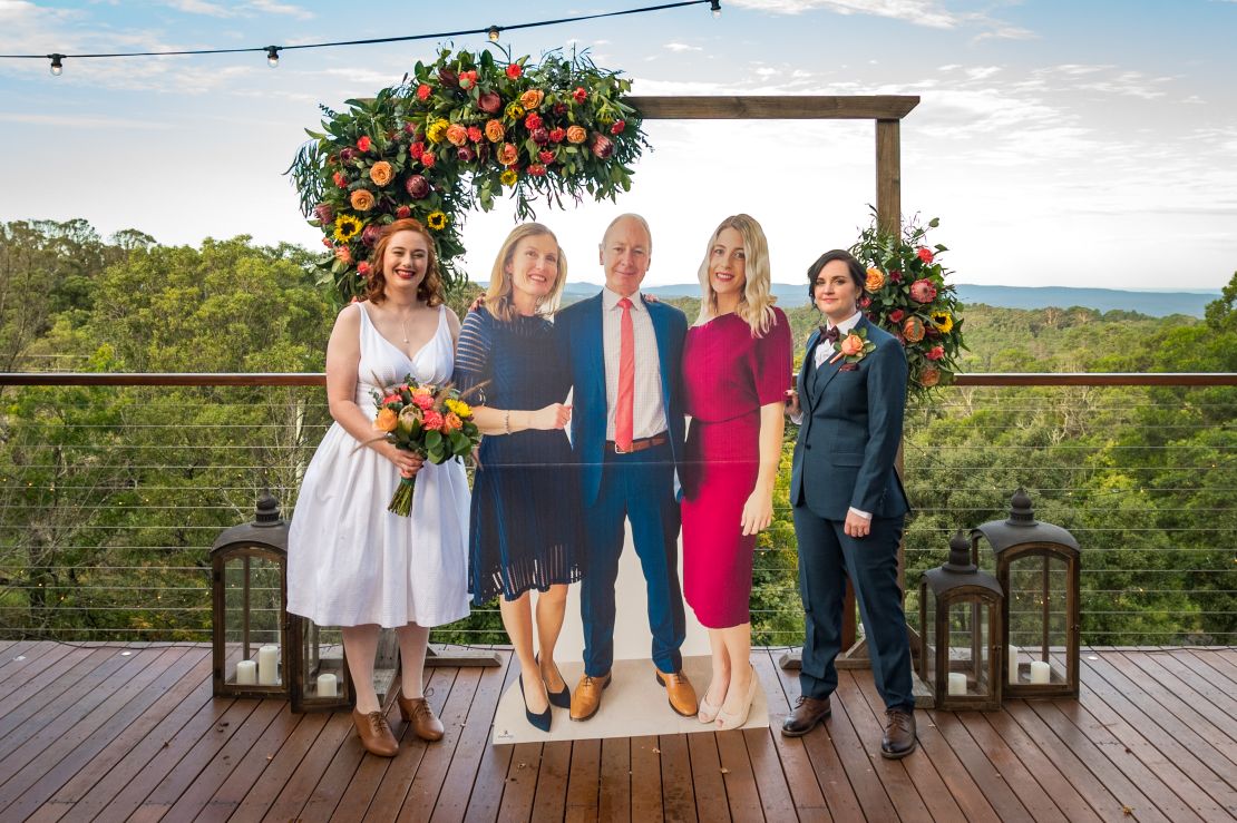 Laura and Sara at their wedding, with the life-size cardboard cutouts of Laura's parents.