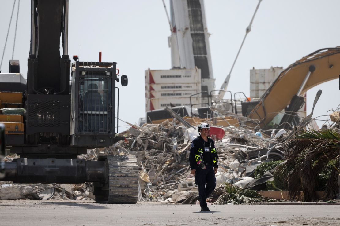 A worker walks away from the remains of the collapsed condo building on July 8.