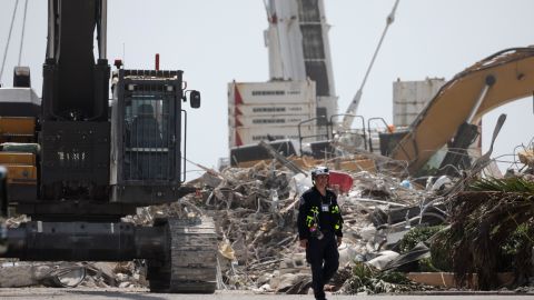 A worker walks away from the remains of the collapsed condo building on July 8.