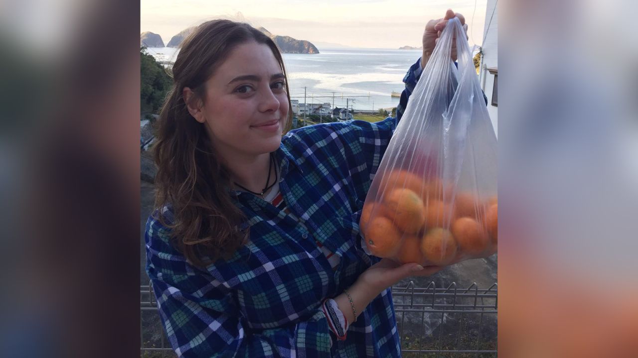 The writer holds one of the many bags of oranges given to her by Ena's farmers.