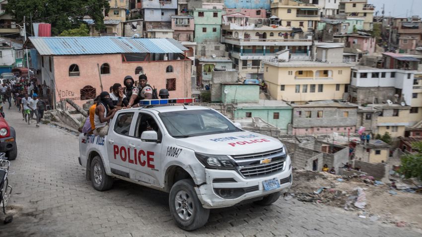 A police car filled with civilians and policemen drives up the Jalousie township where men accused of being involved in the assassination of President Jovenel Moise, have been arrested on July 8, 2021 at the Jalousie township in Haiti. - Police in Haiti have surrounded a group of possible suspects in the assassination of President Jovenel Moise, the UN envoy to Haiti said. Helen La Lime said from the Haitian capital that four members of a group that attacked the presidential palace Wednesday and shot the president have been killed by police and six others are in custody. (Photo by Valerie Baeriswyl / AFP) / The erroneous mention[s] appearing in the metadata of this photo by Valerie Baeriswyl has been modified in AFP systems in the following manner: [A police car filled with civilians and policemen drives up the Jalousie township where men accused of being involved in the assassination of President Jovenel Moise, have been arrested] instead of [Men accused of being involved in the assassination of President Jovenel Moise, are being transported]. Please immediately remove the erroneous mention[s] from all your online services and delete it (them) from your servers. If you have been authorized by AFP to distribute it (them) to third parties, please ensure that the same actions are carried out by them. Failure to promptly comply with these instructions will entail liability on your part for any continued or post notification usage. Therefore we thank you very much for all your attention and prompt action. We are sorry for the inconvenience this notification may cause and remain at your disposal for any further information you may require. (Photo by VALERIE BAERISWYL/AFP via Getty Images)