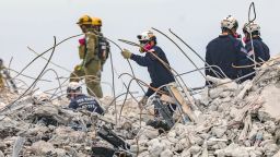 Search and rescue team members dig through the debris field of the 12-story oceanfront condo, Champlain Towers South along Collins Avenue in Surfside, Fla., on Wednesday, July 7, 2021. (Al Diaz/Miami Herald via AP)