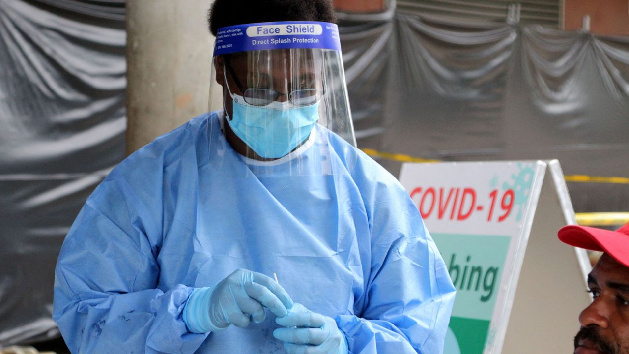 A health worker prepares to take a swab at a makeshift clinic in a sports stadium in Port Moresby on April 1, 2021.