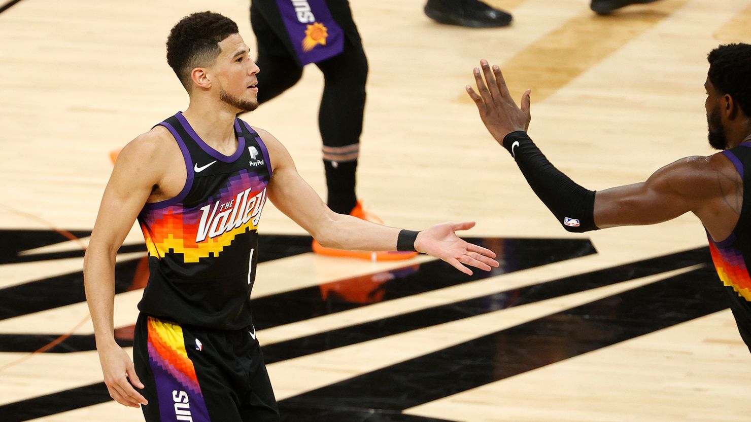 Devin Booker #1 of the Phoenix Suns is congratulated by teammates while coming to the bench for a time out during the second half in Game Two of the NBA Finals against the Milwaukee Bucks at Phoenix Suns Arena on July 08, 2021 in Phoenix, Arizona.