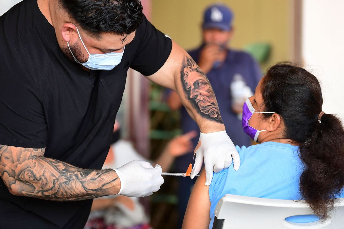 Respiratory therapist Robert Blas  administers the Covid-19 vaccine at a mobile clinic to residents in an East Los Angeles neighborhood which has a low vaccination rates, especially among the young.
