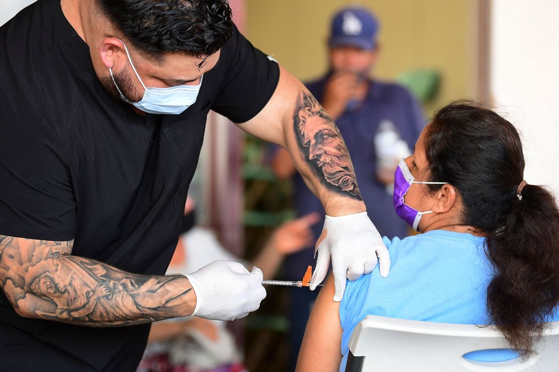Respiratory therapist Robert Blas administers the Covid-19 vaccine at a mobile clinic to residents in an East Los Angeles neighborhood which has a low vaccination rates, especially among the young.