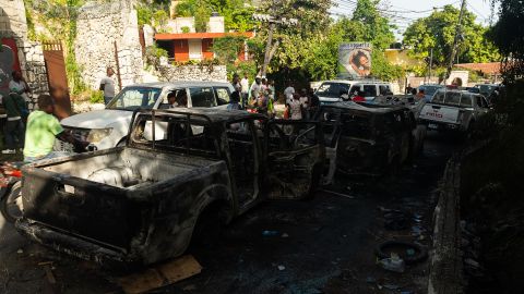 Burnt out cars line the street near the late President's residence in Haiti.