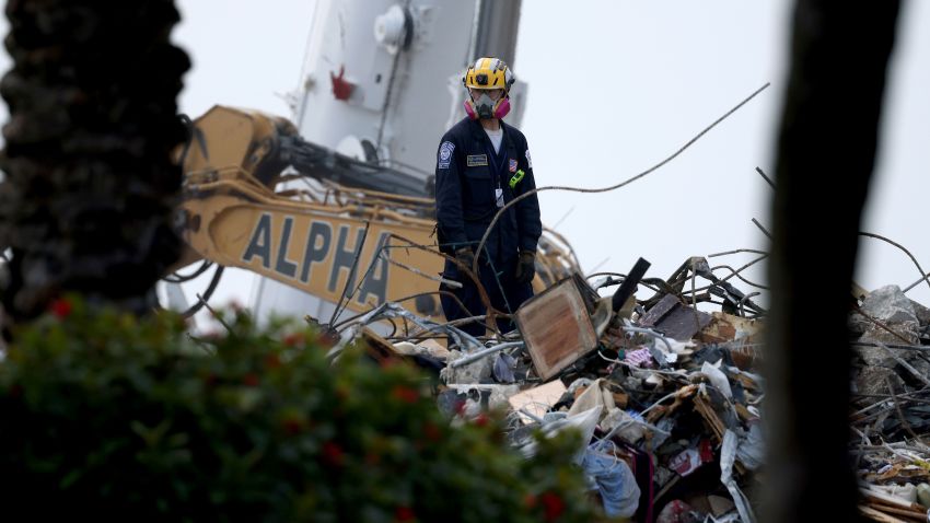 SURFSIDE, FLORIDA - JULY 10: A rescue worker works on top of the collapsed 12-story Champlain Towers South condo building on July 10, 2021 in Surfside, Florida. With the death toll currently at 86 people, search and rescue personnel continue their efforts as more grow concerned about the air quality of Surfside. (Photo by Anna Moneymaker/Getty Images)