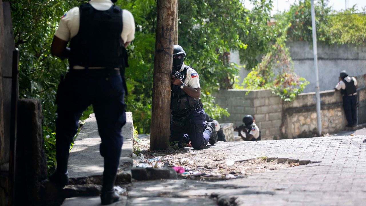 Police search the Morne Calvaire district of Petion-Ville for suspects who remain at large in the murder.