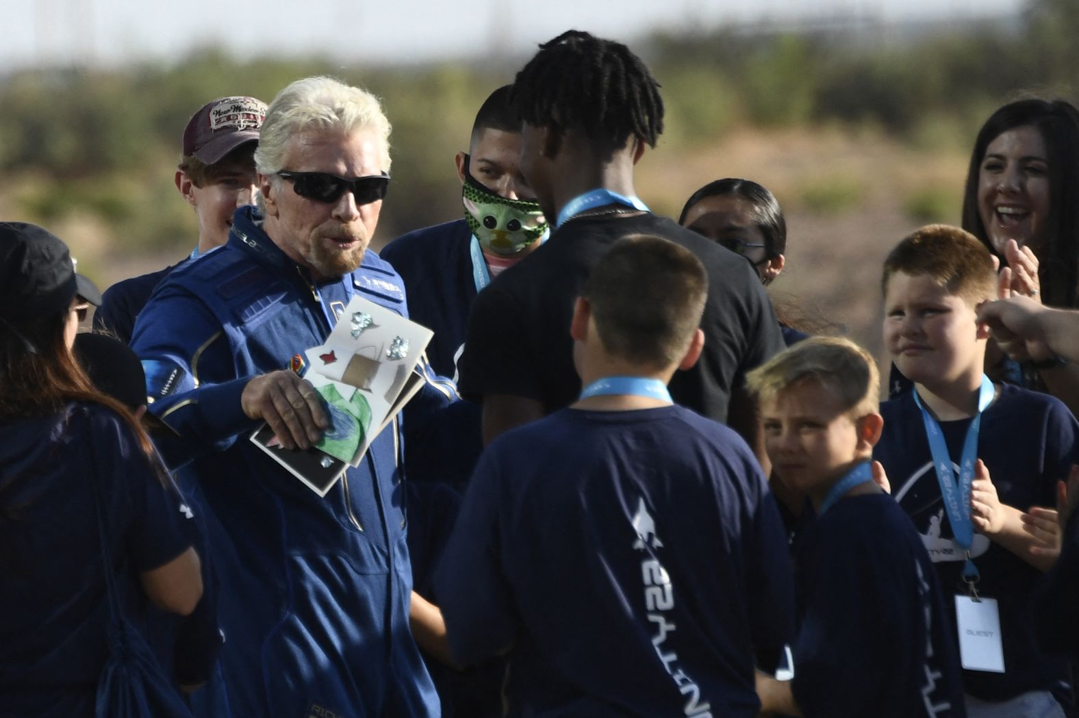 Richard Branson receives some cards from schoolchildren as he walks out ahead of the flight.