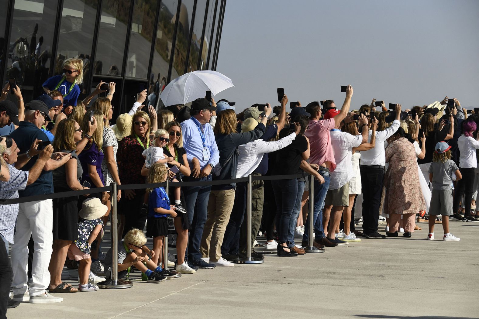 Spectators take photos and cheer as the Virgin Galactic space plane takes off.