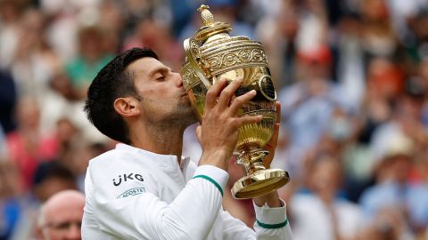 TOPSHOT - Serbia's Novak Djokovic kisses the winner's trophy after beating Italy's Matteo Berrettini during their men's singles final match on the thirteenth day of the 2021 Wimbledon Championships at The All England Tennis Club in Wimbledon, southwest London, on July 11, 2021. - RESTRICTED TO EDITORIAL USE (Photo by Adrian DENNIS / AFP) / RESTRICTED TO EDITORIAL USE (Photo by ADRIAN DENNIS/AFP via Getty Images)