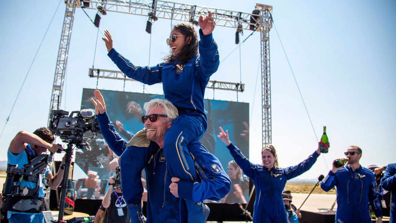 Virgin Galactic founder Richard Branson carries crew member Sirisha Bandla on his shoulders while celebrating their flight to space at Spaceport America near Truth or Consequences, New Mexico, Sunday, July 11, 2021. (AP Photo/Andres Leighton)