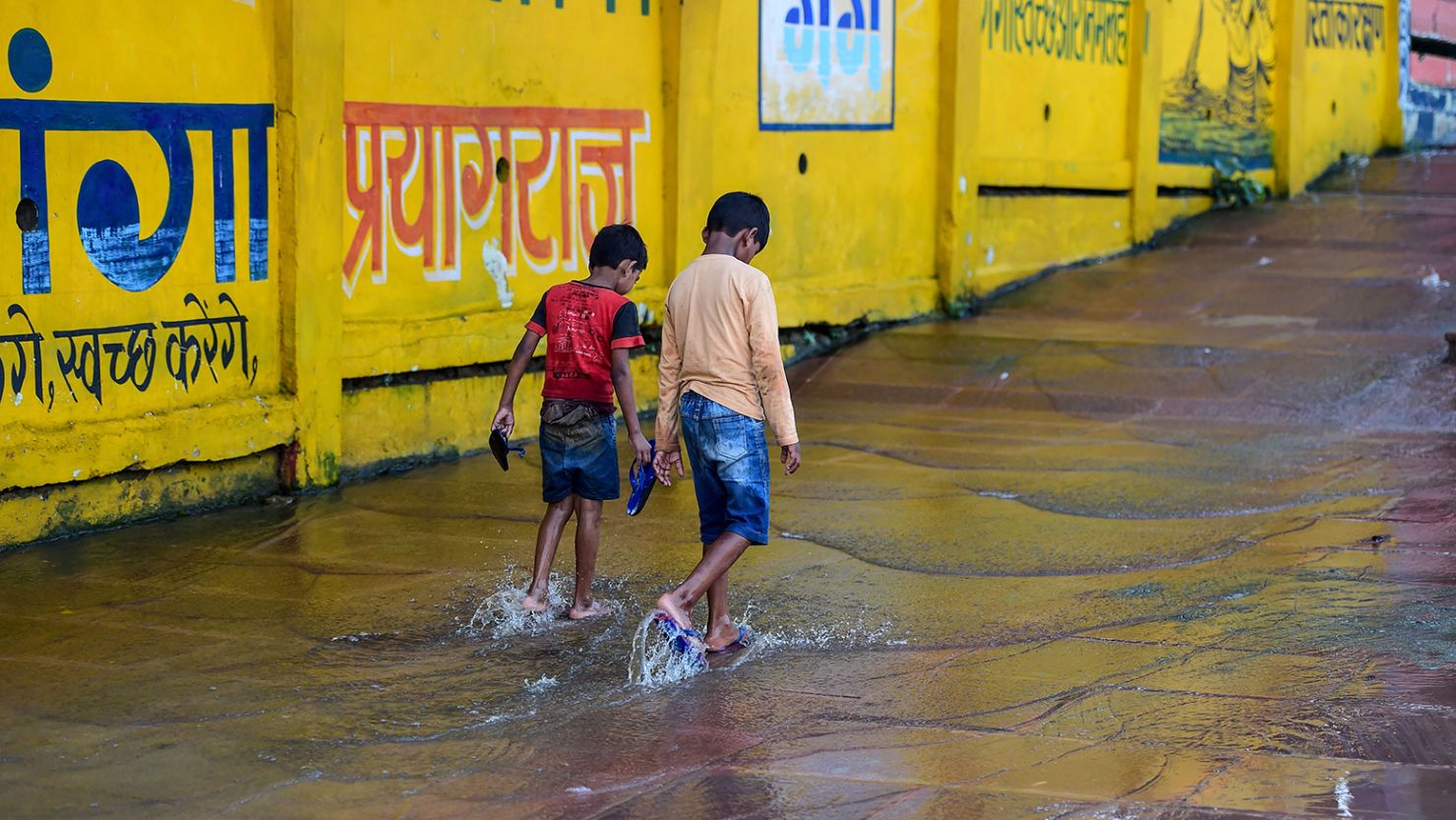 Children play in the rain water during heavy rain in Allahabad on August 19, 2020. (Photo by SANJAY KANOJIA / AFP) (Photo by SANJAY KANOJIA/AFP via Getty Images)