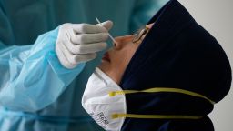 A woman has her nasal swab samples collected during a mass testing for COVID-19 in Bekasi on the outskirts of Jakarta, Indonesia, Tuesday, June 29, 2021. 