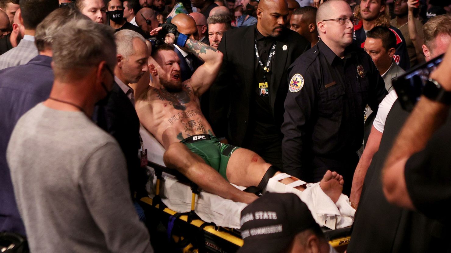 McGregor is carried out of the arena on a stretcher after injuring his ankle in the first round of his lightweight bout against Poirier.