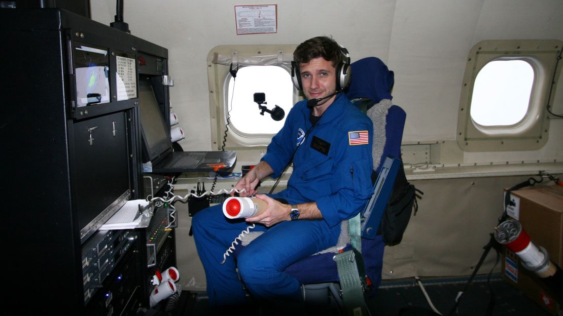 NOAA hurricane hunter, Nick Underwood, holds a dropsonde -- which collects data around the storm.
