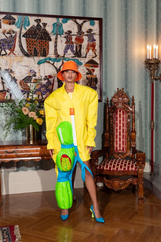 A model wearing one of the most colorful looks of the collection: a Super Soaker-inspired blazer and bucket hat.
