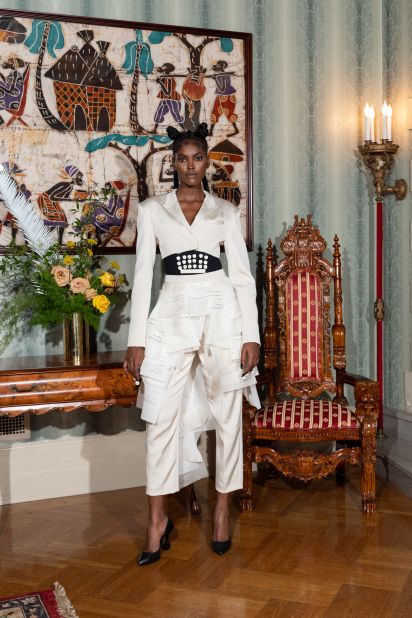 A typewriter-inspired white suit, featuring fabric sheaves of "paper."