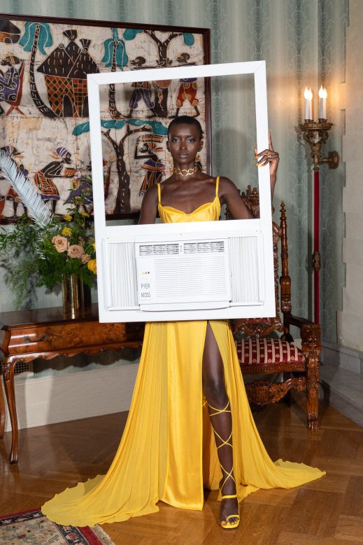 A model holds up a faux air-conditioning unit.