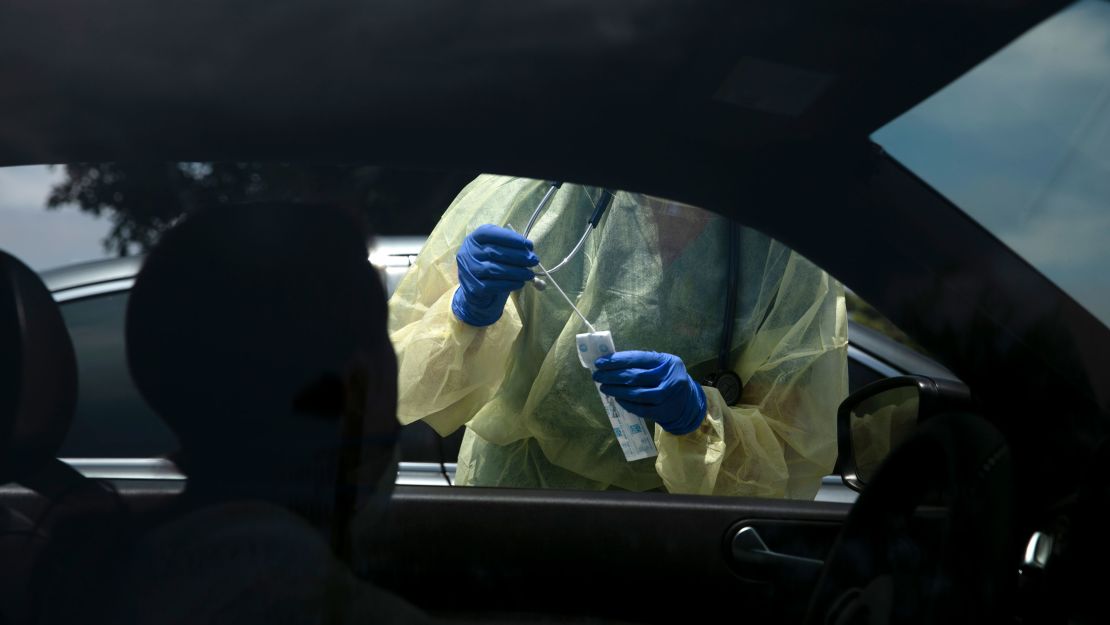 Physician assistant Nicole Kramer prepares to collect a nasal swab sample from a patient for coronavirus testing at Xpress Urgent Care in Tustin, California, on June 25, 2020.