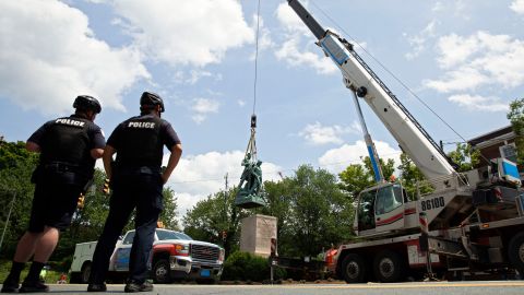 Police look on as the statue of Meriwether Lewis, William Clark and Sacagawea is removed from Charlottesville, Virginia on July 10, 2021. 