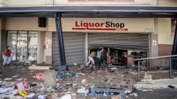 Rioters run away from police officers (not seen) after looting a liquor shop at the Jabulani Mall in the Soweto district of Johannesburg, on July 12, 2021. - South Africa said it was deploying troops to two provinces, including Johannesburg, after unrest sparked by the jailing of ex-president Jacob Zuma led to six deaths and widespread looting. Overwhelmed police are facing mobs who have ransacked stores. Six people have died, some with gunshot wounds, and 219 people have been arrested, according to a police tally issued before the army deployed. (Photo by LUCA SOLA / AFP) (Photo by LUCA SOLA/AFP via Getty Images)
