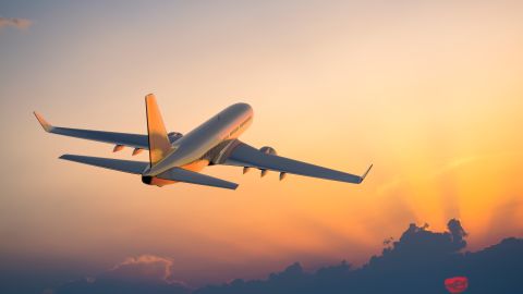 underscored unidentified commercial airplane flying in sky during sunset